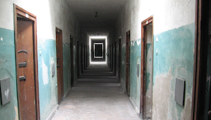 A corridor of closed prison cell doors
